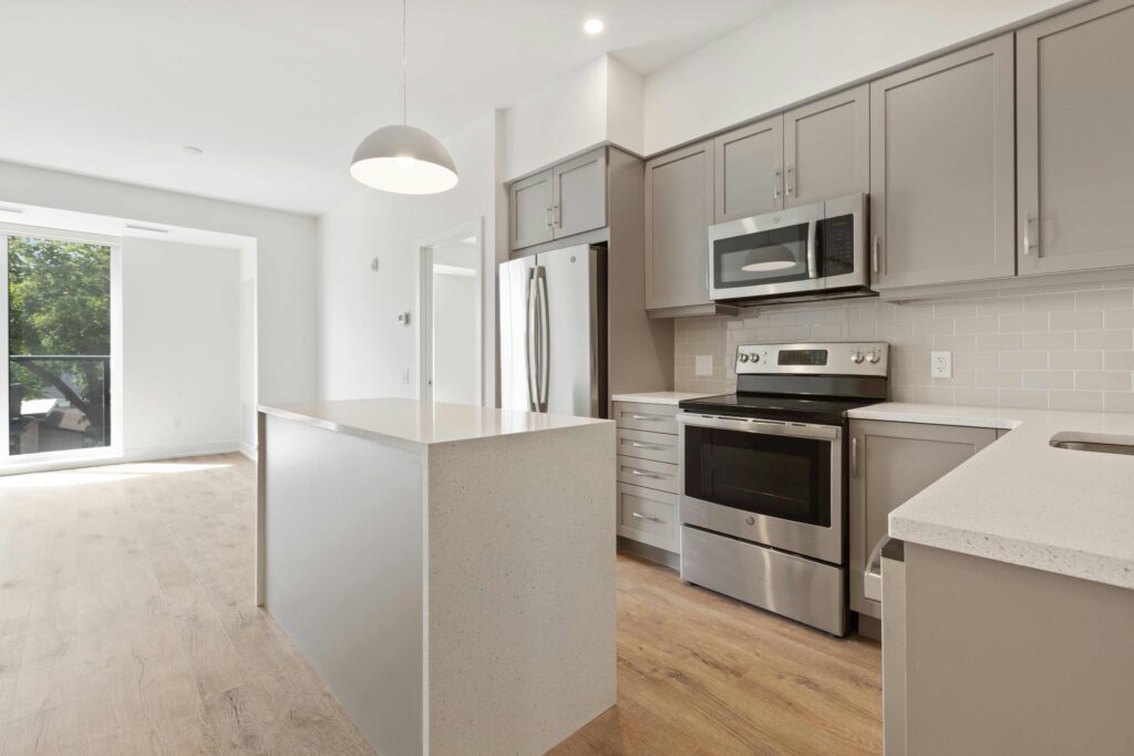 Modern kitchen with white and black cabinetry featuring stainless steel appliances.
