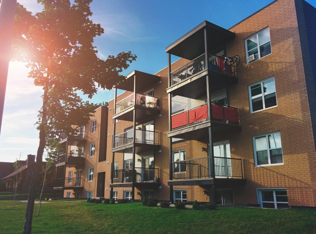 Four-story brown brick building with multiple balconies.